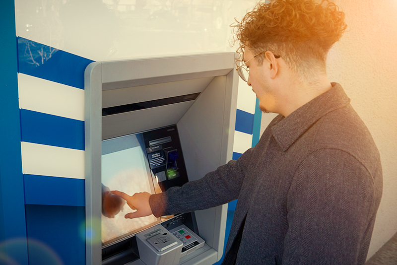 Man using walk up self-service, core-integrated ITM